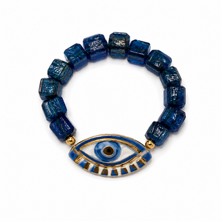 Cobalt blue glass cube beaded bracelet with hand-painted blue and gold evil eye charm, close-up