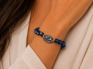 Cobalt blue glass cube beaded bracelet with hand-painted blue and gold evil eye charm
