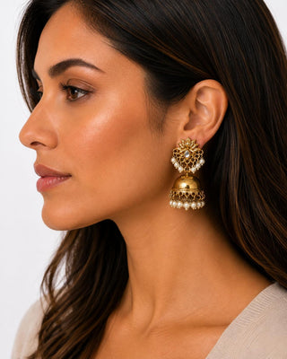 Woman wearing antique gold-tone lotus jhumka earrings with faux pearl fringe