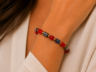 Woman wearing red, navy and charcoal striped bead stretch bracelet with gold-tone spacers