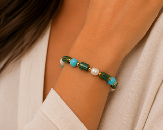 Woman wearing turquoise, faux pearl, and iridescent bamboo bead stretch bracelet
